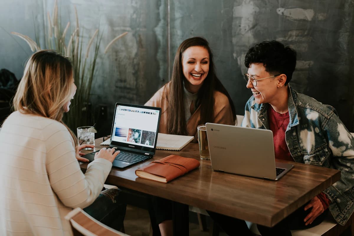 Adults collaborating around a table with laptops and notes
