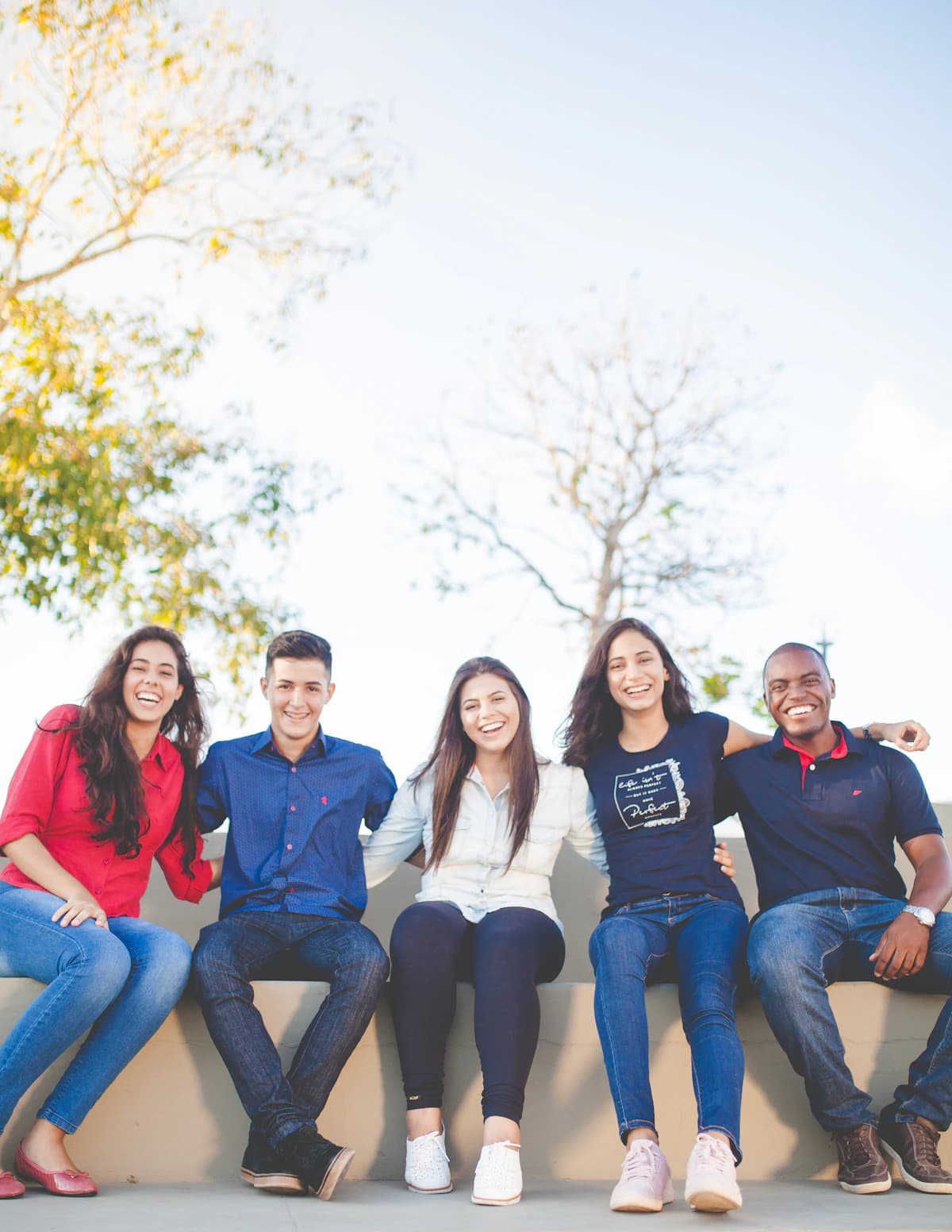 A diverse group of young adults sitting together outdoors
